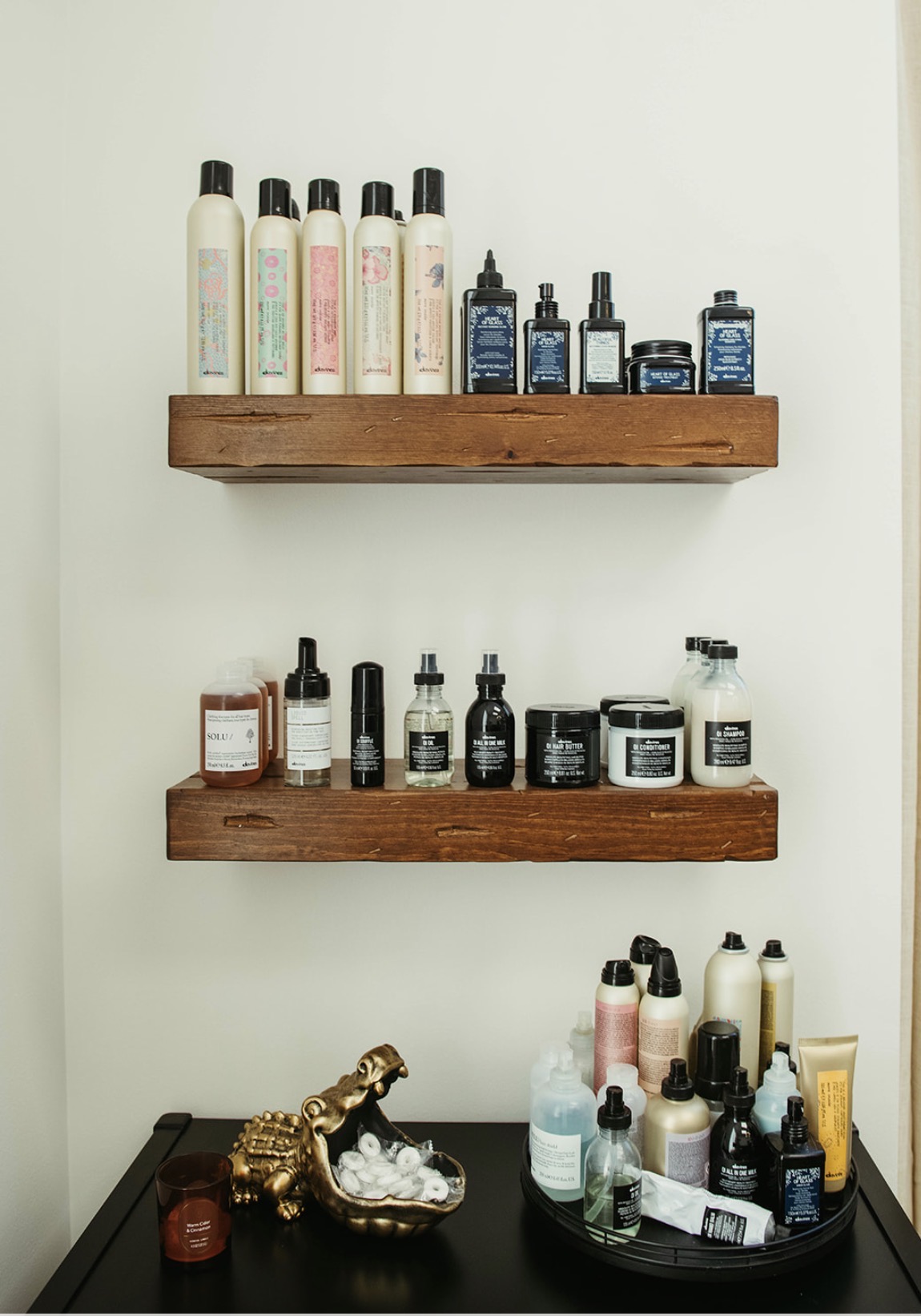 Davines products on floating wooden shelves at Mane Haven