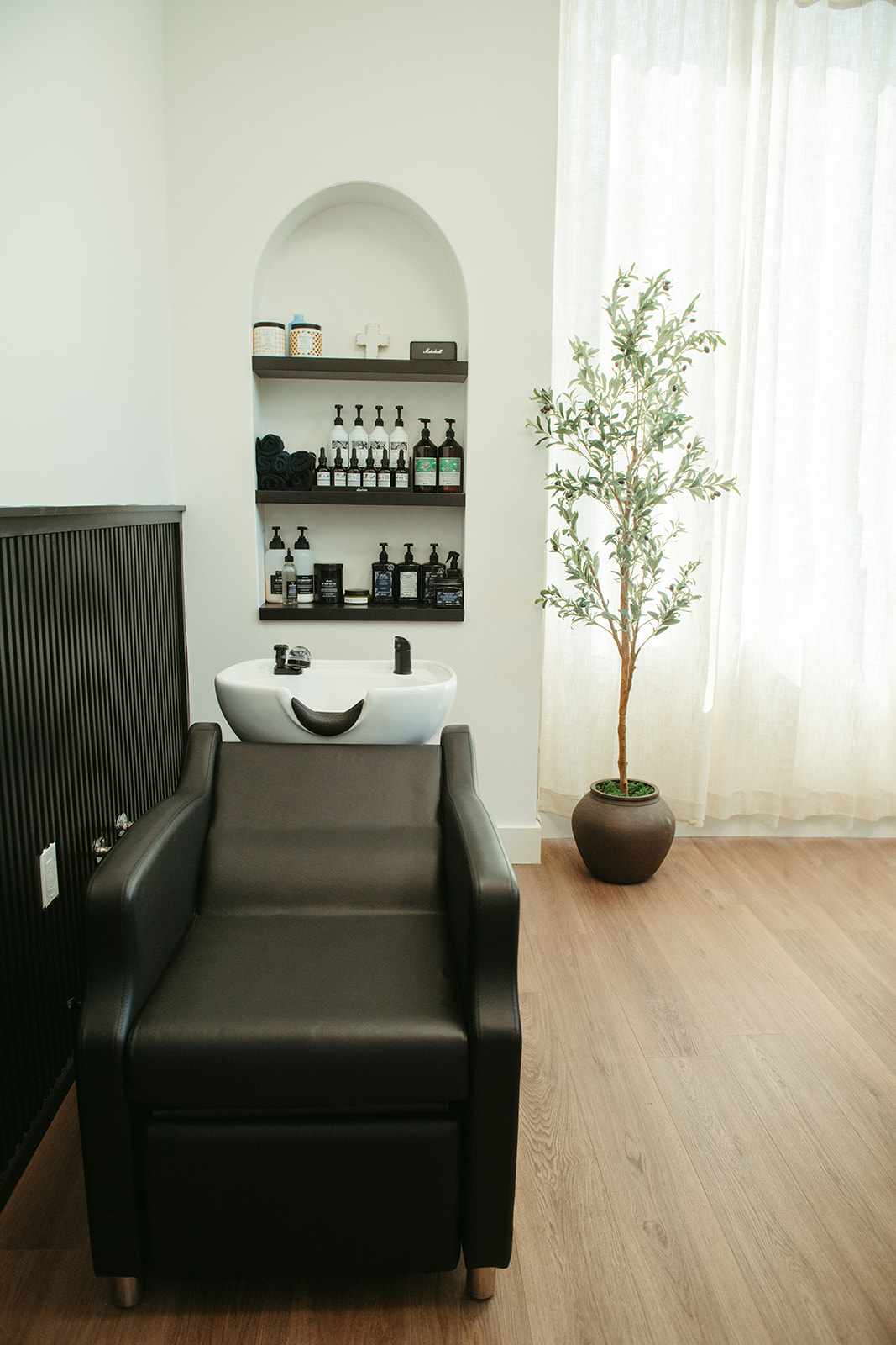 The shampoo station with arched shelving and an olive tree