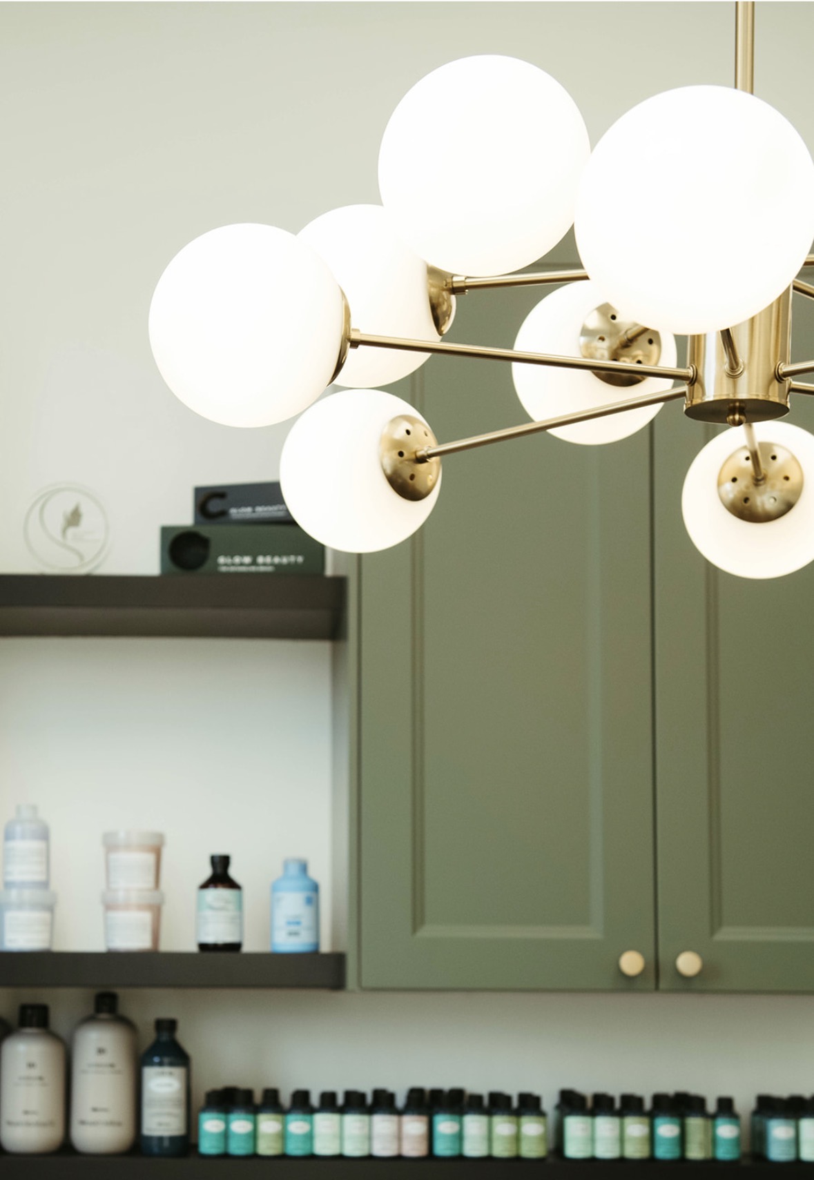 Close-up of the brass globe chandelier and product shelves