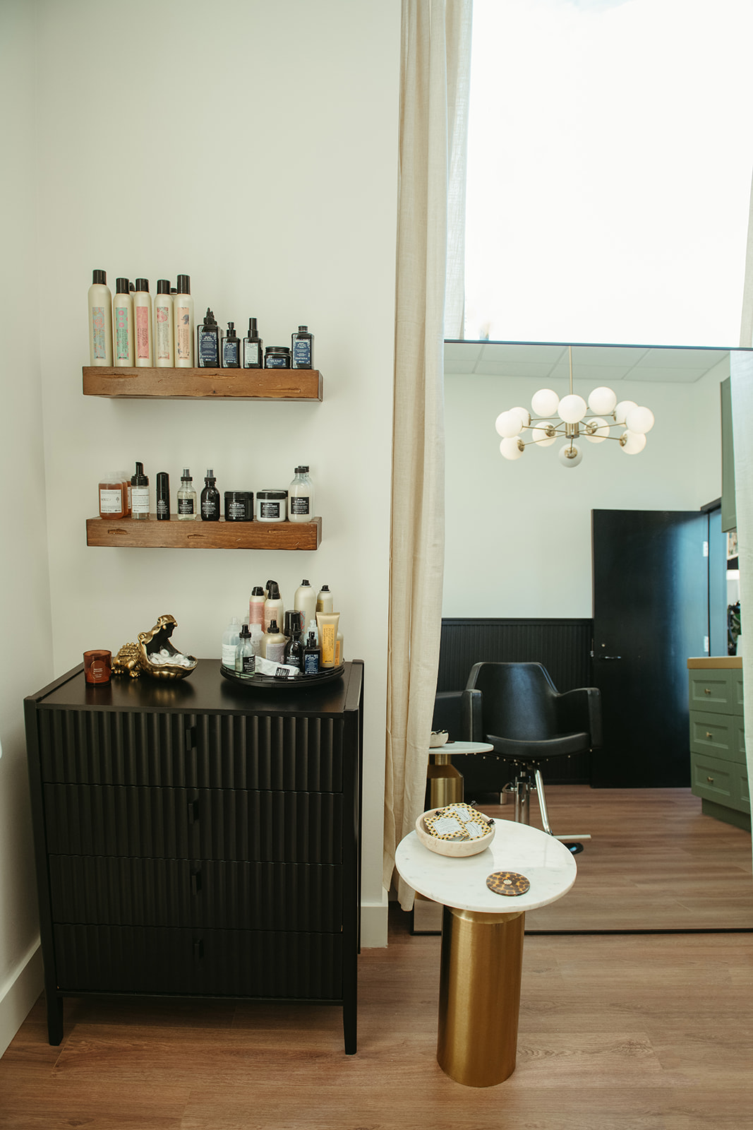 Product shelves, black dresser and marble side table in the studio